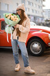 Tenderness girl in knitted sweater, blue jeans and sneakers and vintage car