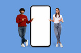 Fototapeta  - Casual Multiracial couple with oversized smartphone mockup