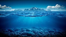   An Underwater Perspective Of A Blue Ocean With A Distant Mountain And Bubbling Foreground Waters