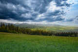 Fototapeta  - zachmurzone burzowe niebo pokryte ciężkimi chmurami nad wysokimi górami 