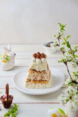 Dessert, cottage cheese Easter in the style of tiramisu with cottage cheese cream and cookies on a ceramic plate on a light concrete background. 