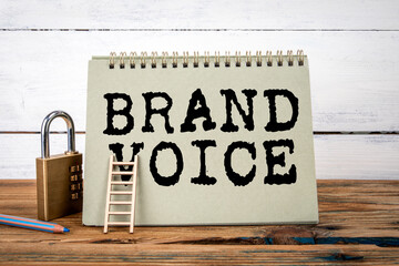 Wall Mural - brand voice. green notepad on wooden texture table and white background