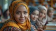 A young woman wearing a brown hijab is smiling at the camera while sitting in a library with her friends in the background.