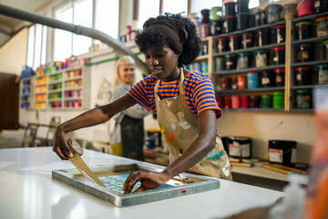 Wall Mural - Multiracial printing shop worker with duck tape preparing printing plate