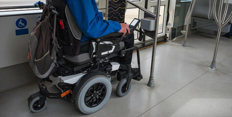 Man with disability with electric wheelchair on train. Inclusive and accessible public transportation concept.