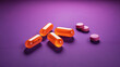 Orange and pink pills in purple light.