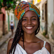 Happy young Afro-Brazilian woman smiling, wearing colorful turban in Pelourinho, the Historic Center of Salvador, Bahia, Brazil.