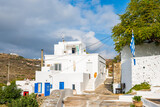Fototapeta  - View of Kastro village buildings from coastal promenade with mountain ladscape in background, Sifnos island, Greece