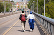 Young Muslim couple walking arm in arm in Basel city street, rear view