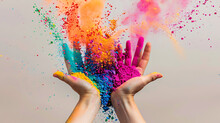 A Pair Of Hands Surrounded By An Explosion Of Vibrant Powders Or Paints. The Hands, With Fingers Slightly Curled, Reach Upwards As If Releasing Or Catching Something