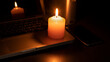 Blackout concept, A lit white candle on a laptop