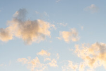 Close Up Of Ethereal Clouds At Twilight With Yellow Tint Against A Beautiful Blue Sky