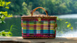 a colorful checkered picnic basket placed on a wooden surface.