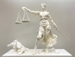An origami representation of Lady Justice on a white background, embodying the balance of law.