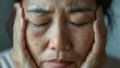 The problem of Asian woman's face, freckles, dark spots and wrinkles on the faces of middle-aged women stressed expression, close eyes frowning, dry, darkened, rough skin and facial healthy concept.

