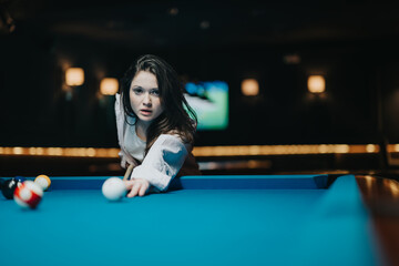 Wall Mural - Intense concentration captured as a young woman lines up her shot at a pool table in a moody bar atmosphere.