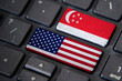 USA and Singapore flags on computer keyboard