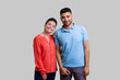 Portrait of smiling positive couple man and woman standing together looking at camera expressing optimistic emotions. Indoor studio shot isolated on gray background.
