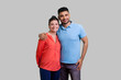 Portrait of loving smiling couple man and woman standing together and hugging expressing happiness and love, family relationship. Indoor studio shot isolated on gray background.