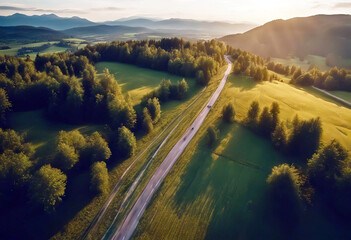 Wall Mural - 'view summer Top meadows road sun Slovenia hills rays roadway drone green trees Aerial Beautiful green landscape grass view road mountains rural clouds forest sunset Road Green Aerial Landscape'