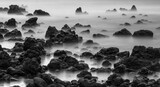 Fototapeta  - Black and white long exposure of ocean and lava rocks
