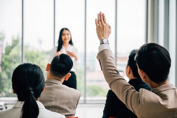 Wall Mural - Active engagement is evident as a large group in a seminar classroom raises their hands to participate in the discussion. This dynamic conference audience is poised with answers.