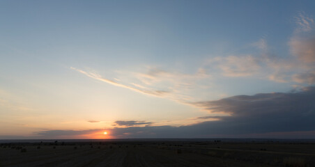 Wall Mural - Landscape with bloody sunset. Panorama. Tragic gloomy sky. The last flashes of the sun on the storm clouds.