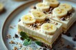Banana cream cheesecake bars with banana slices. Close-up of banana cream cheesecake with cinnamon powder in a mouth-watering presentation.