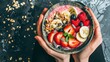 A fitness enthusiast enjoying a post-workout smoothie bowl topped with fresh fruit, nuts, and seeds for a delicious and nourishing treat.