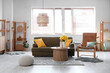 Stylish interior of living room with cozy sofa, coffee table and bouquet of narcissus flowers