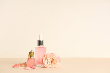 Wall Mural - Composition with bottles of cosmetic oil, petals and roses on light background