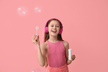 Sticker - Happy girl in headphones with soap bubbles on pink background