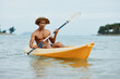 Happy Asian man enjoying active kayaking adventure on a tropical beach