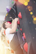 Confident male mountaineer climbing artificial rock wall without belay indoors