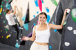 Young sports woman posing against background of wall at climbing wall