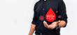 man holding red paper dripping blood. World Blood Donor Day