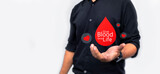 Fototapeta  - man holding red paper dripping blood. World Blood Donor Day
