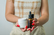 Young woman holding and showing with her hands set of skin care products, serum, creams, personal beauty care concept.