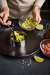 Tuna and avocado tartare recipe - woman fills cooking form with sliced chopped avocado