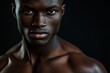 © LimeSky - Shirtless African male model with a muscular build posing for a close up photo gazing at the camera on a black background