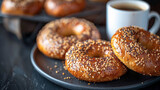 Fototapeta Mapy - Delicious breakfast bagel on dark plate next to a cup of fresh coffee. On bistro countertop. 