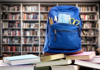 Canvas Print - school backpack with stationery on table in labrary