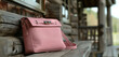 A chic crossbody bag in soft pastel pink, resting gracefully on a wooden bench, adding a touch of femininity to any ensemble