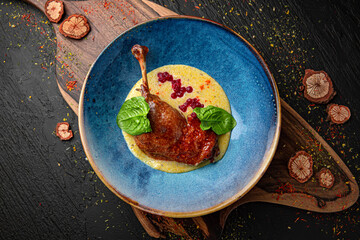 Wall Mural - Duck Confit - French slow roasted duck legs. Menu for a pub on a dark background. Colorful juicy food photography.