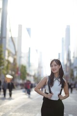 Wall Mural - Wander through urban elegance with a happy Asian woman, her confident stride reflecting a perfect fusion of style and joy.