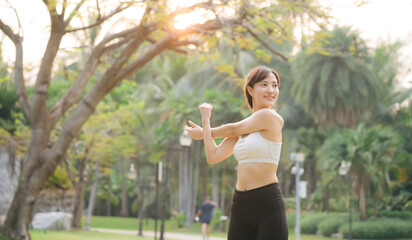 Wall Mural - Female sportswoman. Fit young Asian woman with sportswear stretching muscle in park before running and enjoying healthy outdoor. Fitness runner girl in public park. Wellness being concept