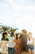 © Xavier Lorenzo - Millennial group of young friends walking together in summer. Diverse people hugging each other while hanging out at the beach during vacation. Holiday lifestyle and friendship concept.