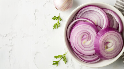 Wall Mural - Onion slices in a white bowl on a white table, top view, space on the left