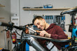 © Jordi Mora - Smiling bike mechanic while manipulating the handlebar of an electric mountain bike with a ratchet wrench.