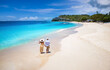 Elevated view of a couple walking down the beuatiful Darkwood beach with turquoise sea in the Caribbean, Antigua and Barbuda islands